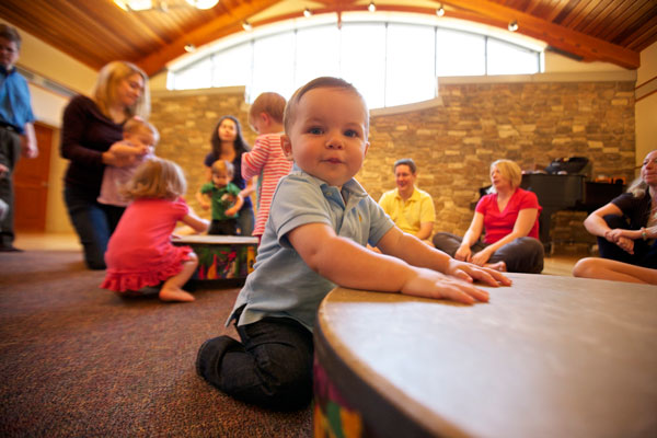 Toddler boy with gathering drum in Music Together class