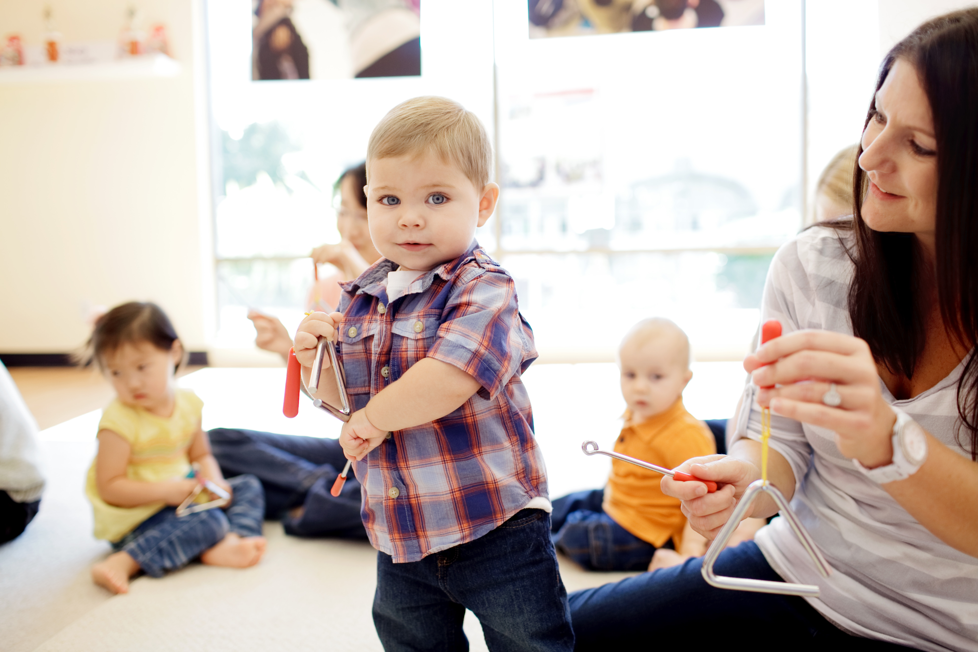 Families play the triangle in Music Together class.