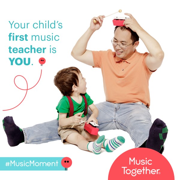 A father and son play with musical instruments.