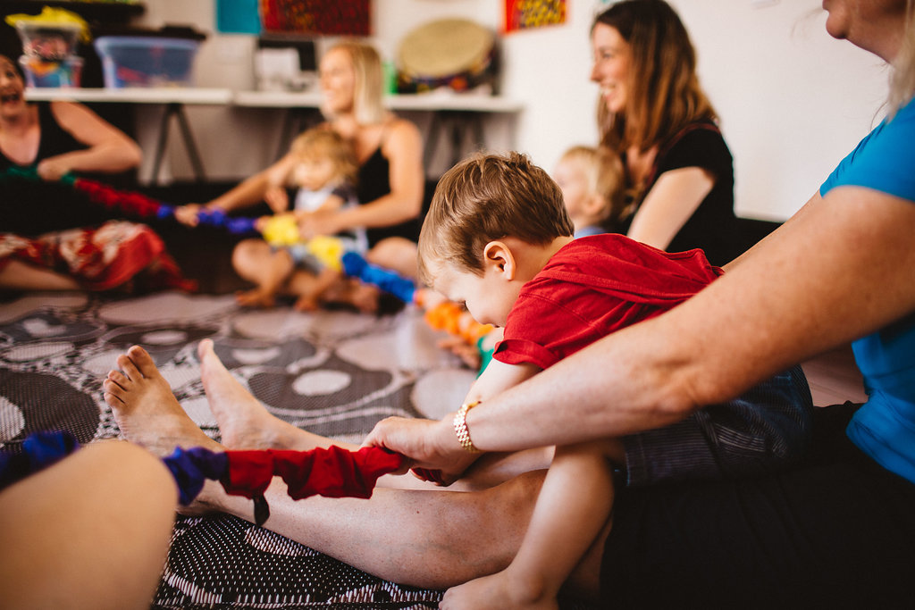 Families sitting in a circle singing 