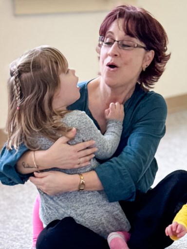 Mom and preschooler rocking and singing together in music class