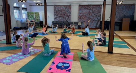 Children in a circle of yoga mats taking class in Baxter Hall